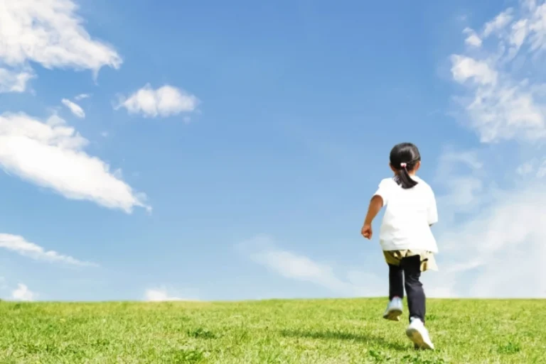 子どもが草原を走る姿