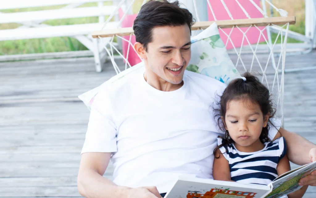 お父さんが子どもに絵本を読んでいるところ