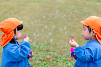 幼稚園児がシャボン玉で遊んでいる様子