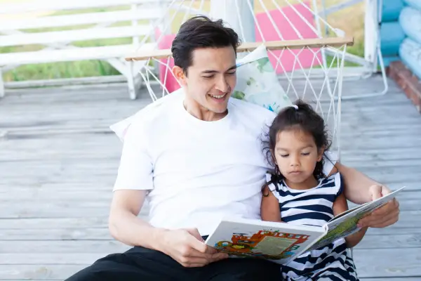 お父さんが子どもに絵本を読んでいるところ